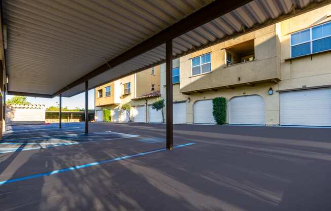 an empty parking lot in front of a building with white garage doors