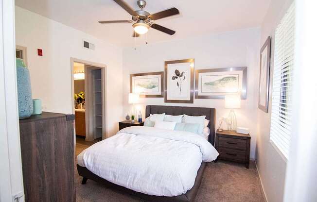 A bedroom with a large bed and a ceiling fan.