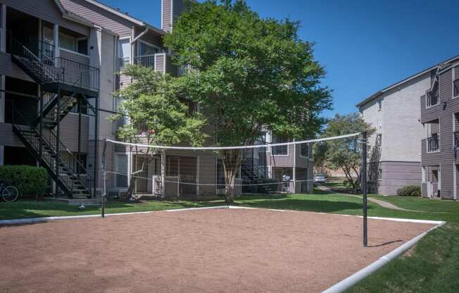 a volleyball court at the whispering winds apartments in pearland, tx