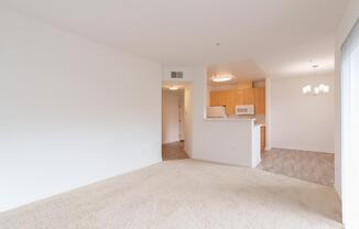 A white room with a carpet and a kitchen area in the background at Cornerstone at Gale Ranch Apartments, San Ramon, CA, 94582