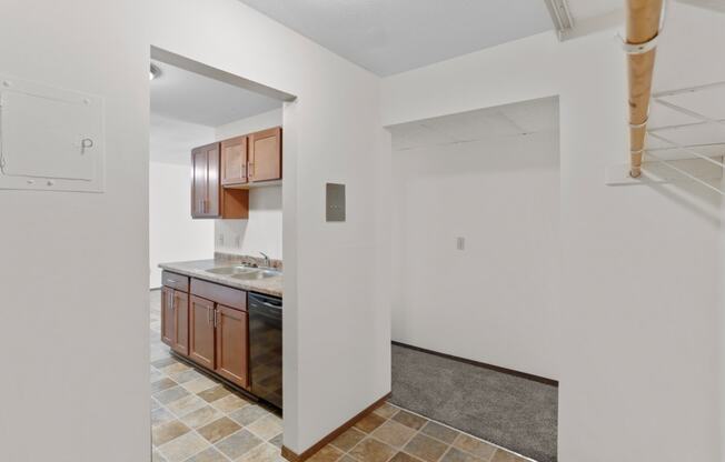 a kitchen with white walls and a tiled floor