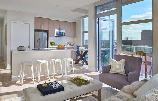A modern living room with a bar area and a view of the city.