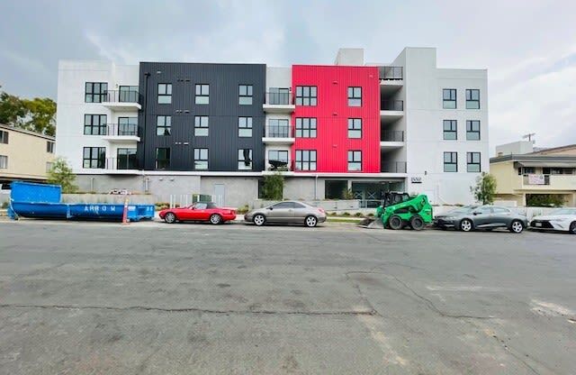 a group of cars parked in front of an apartment building