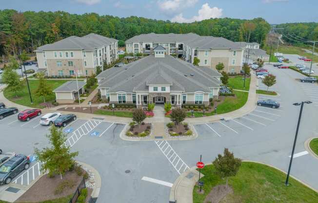 an aerial view of a parking lot with apartments in the background