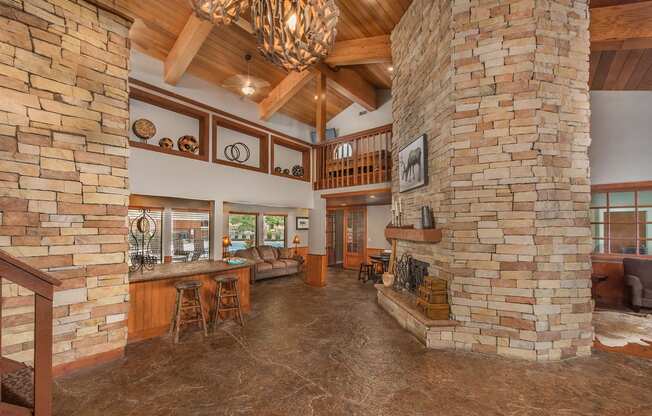 a large living room with a fireplace and a kitchen at Lodge of Overland Park Apartments, Overland Park , Kansas