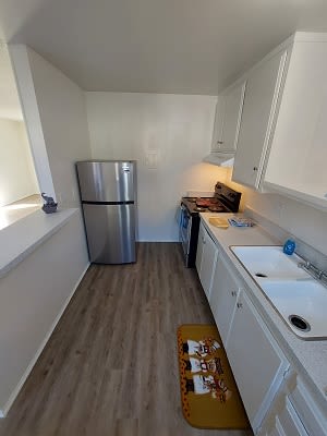 a small kitchen with a sink and a refrigerator