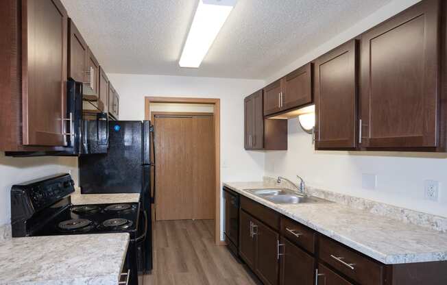 aa kitchen with black appliances. Fargo, ND Country Club Apartments