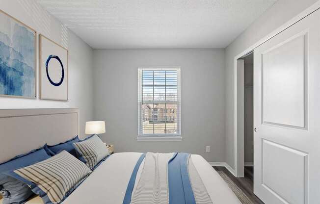 A bedroom with a large bed and a window overlooking a building.