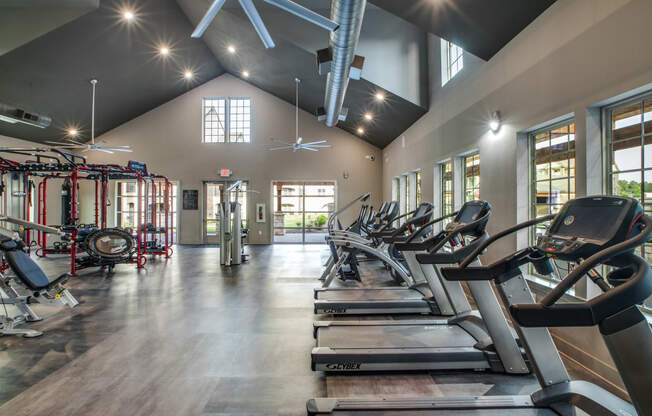 an image of a gym with cardio equipment and windows