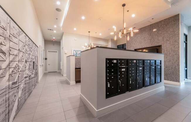 A hallway with a wall of lockers and a chandelier hanging from the ceiling.