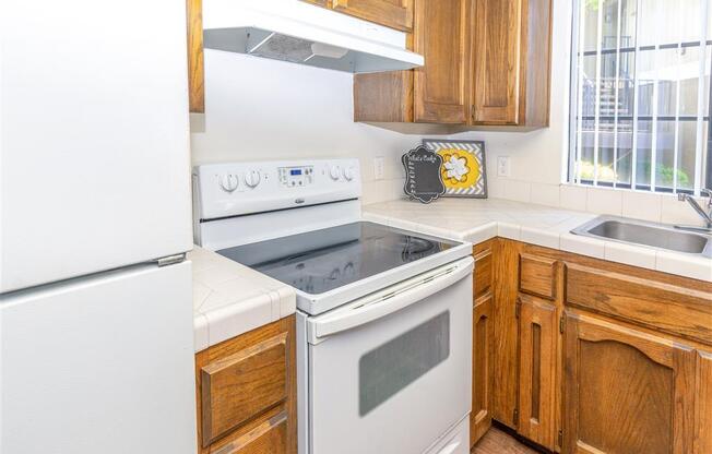 Electric Range In Kitchen at Heron Pointe Apartments & Townhomes, Fresno, CA