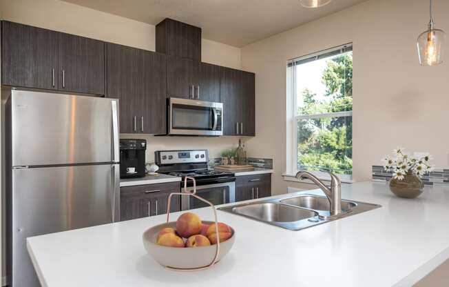 a kitchen with stainless steel appliances and a bowl of fruit