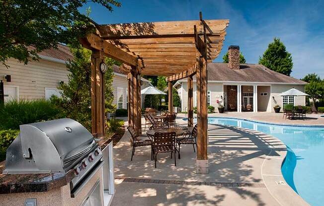 a backyard patio with a grill and a table and chairs