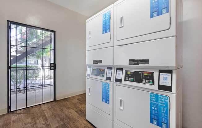 a row of white appliances in a room with a glass door