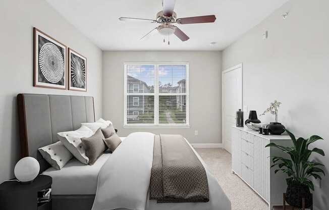 A bedroom with a large bed and a ceiling fan.