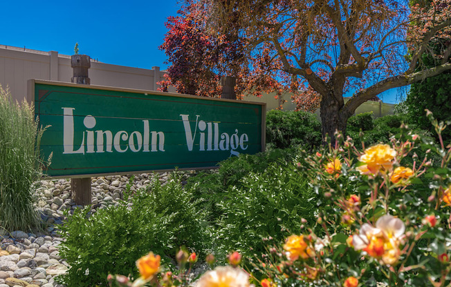 a sign village in front of a garden of flowers at Lincoln Village Apartments, Washington, 99208