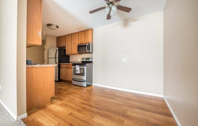 a kitchen and living room with hardwood floors and a ceiling fan