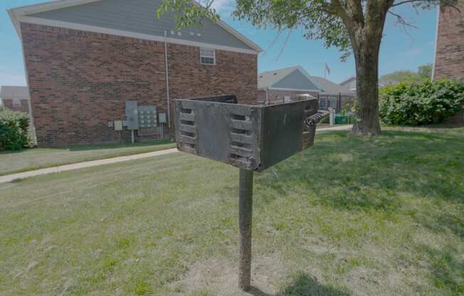 a mailbox in the grass in front of a brick house