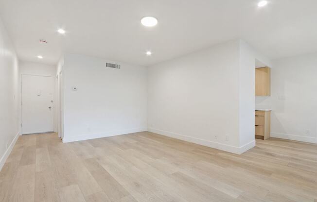 A room with wooden flooring and white walls.