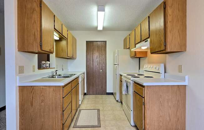 a kitchen with white appliances and wooden cabinets. Fargo, ND Prairiewood Meadows