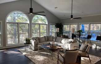 A living room with a white couch, a coffee table, and a rug.