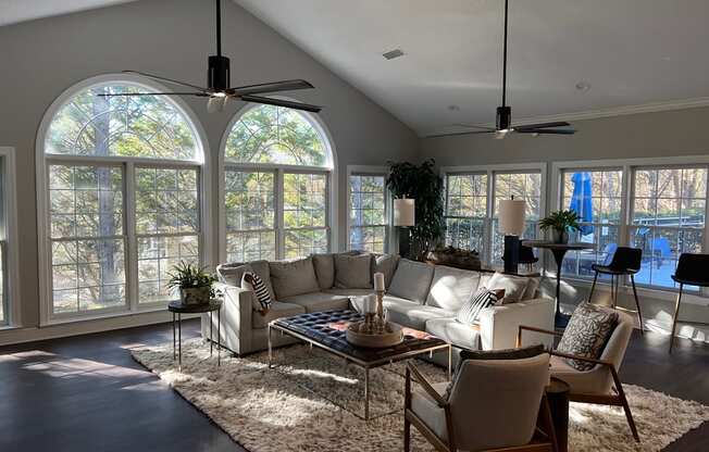 A living room with a white couch, a coffee table, and a rug.