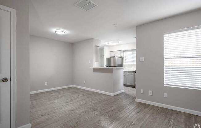 A kitchen area with a refrigerator, sink, and cabinets.