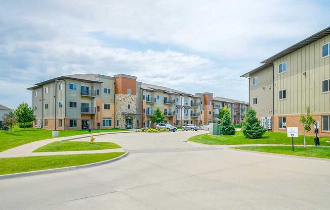 A brick and stone apartment building with professionally landscaped lawns surrounding it.