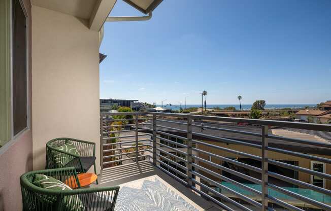 a balcony with chairs and a view of the ocean