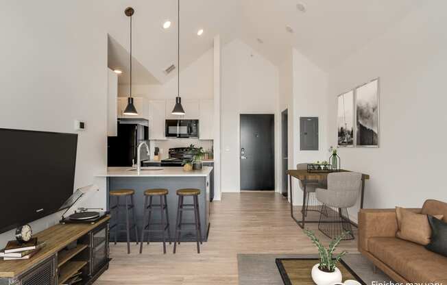 a kitchen and living room with white walls and wood flooring