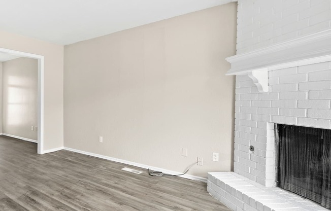 an empty living room with white walls and a fireplace at Diamond Ridge Townhomes, Oklahoma City, OK 73114
