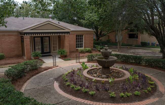 a fountain in front of a brick building