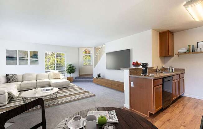 A modern living room with a white sofa and a wooden kitchen area.