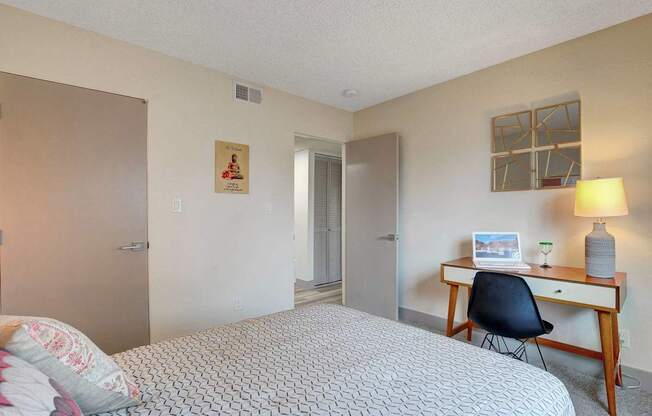 A bedroom with a bed, desk, and chair.