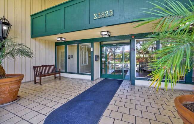 the entrance to a building with glass doors and a rug at Camino de Oro Apartments, California, 90505