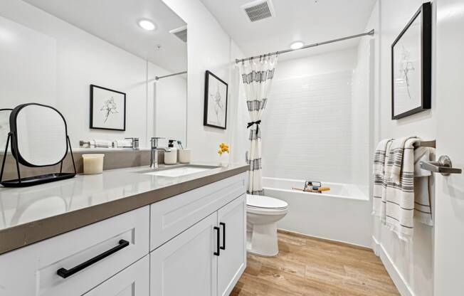 a white bathroom with a shower toilet and sink