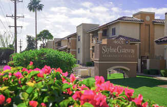 The image shows a beautiful view of the Skyline Gateway Apartment Homes entrance with a sign that reads "4601 Skyline Gateway Apartment Homes".