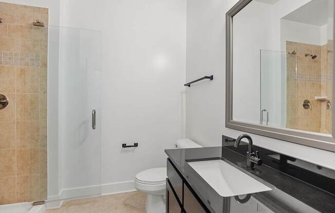 A bathroom with a toilet, sink, and shower.