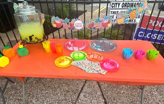 A table with a red tablecloth and various items on it.