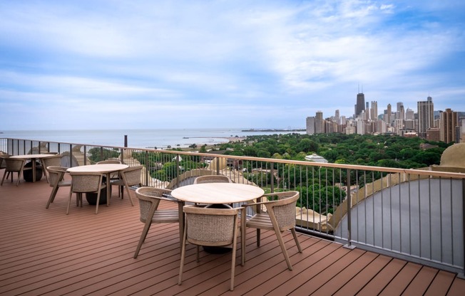 a deck with tables and chairs overlooking a city and the ocean at the Belden Stratford in Chicago, Illinois