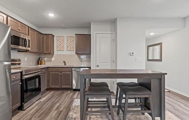 a kitchen with a table and two stools