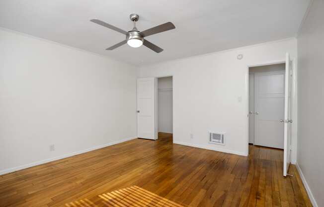 a living room with wood floors and a ceiling fan