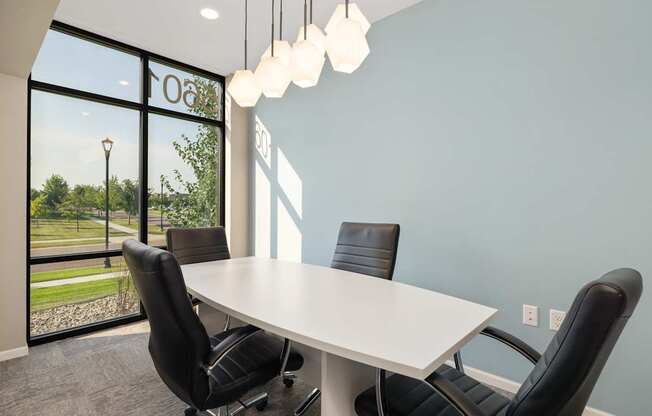 A conference room with a table and chairs.