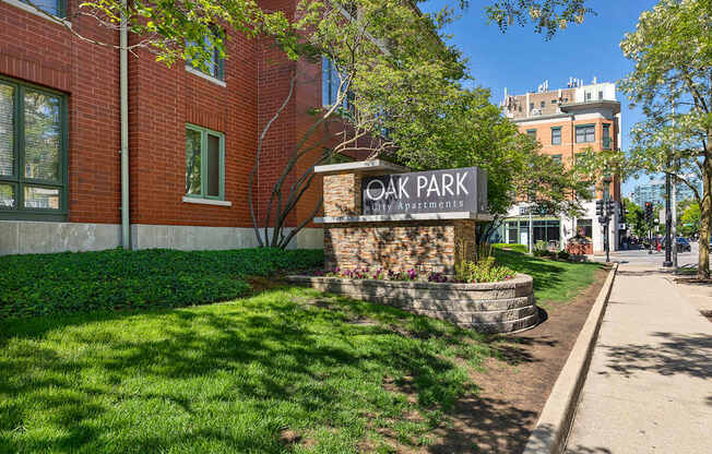 A sign for Oak Park Apartments is in front of a brick building.
