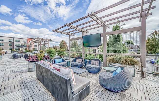 Outdoor patio with couches and a tv at Platform 14, Hillsboro, OR