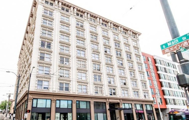 A large building with many windows is located on the corner of a street. at Addison on Fourth Apartments, Seattle, Washington