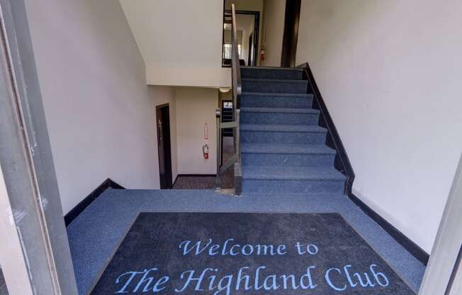 the welcome to the highland club carpet in front of the stairs of a building