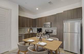 A modern kitchen with a dining table set for two at Infinity on the Point Apartments, Texas