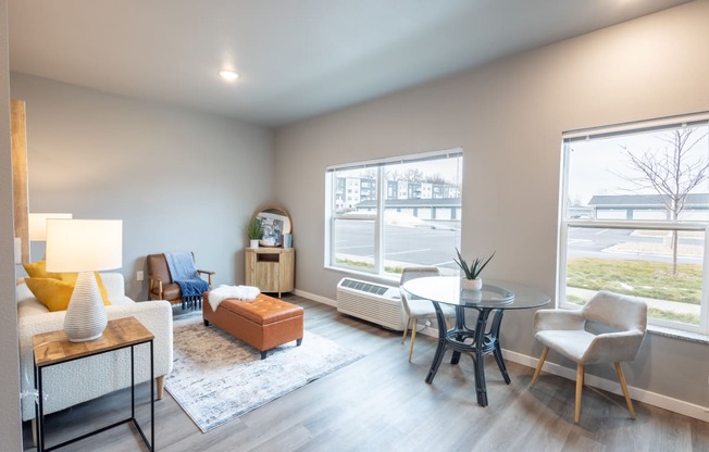 a living room with a table and chairs and a large window at Technology Park Apartments, Rochester, MN