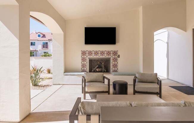 A living room with a fireplace and a flat screen TV mounted on the wall.